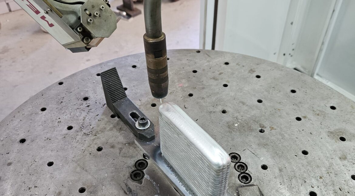 Robotic WAAM system depositing metallic wire layer by layer to manufacture a large industrial metal component