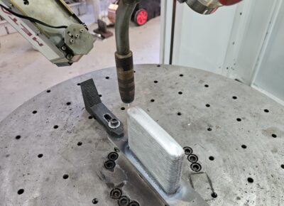 WAAM Applications: Where Is WAAM Technology Used? Robotic WAAM system depositing metallic wire layer by layer to manufacture a large industrial metal component