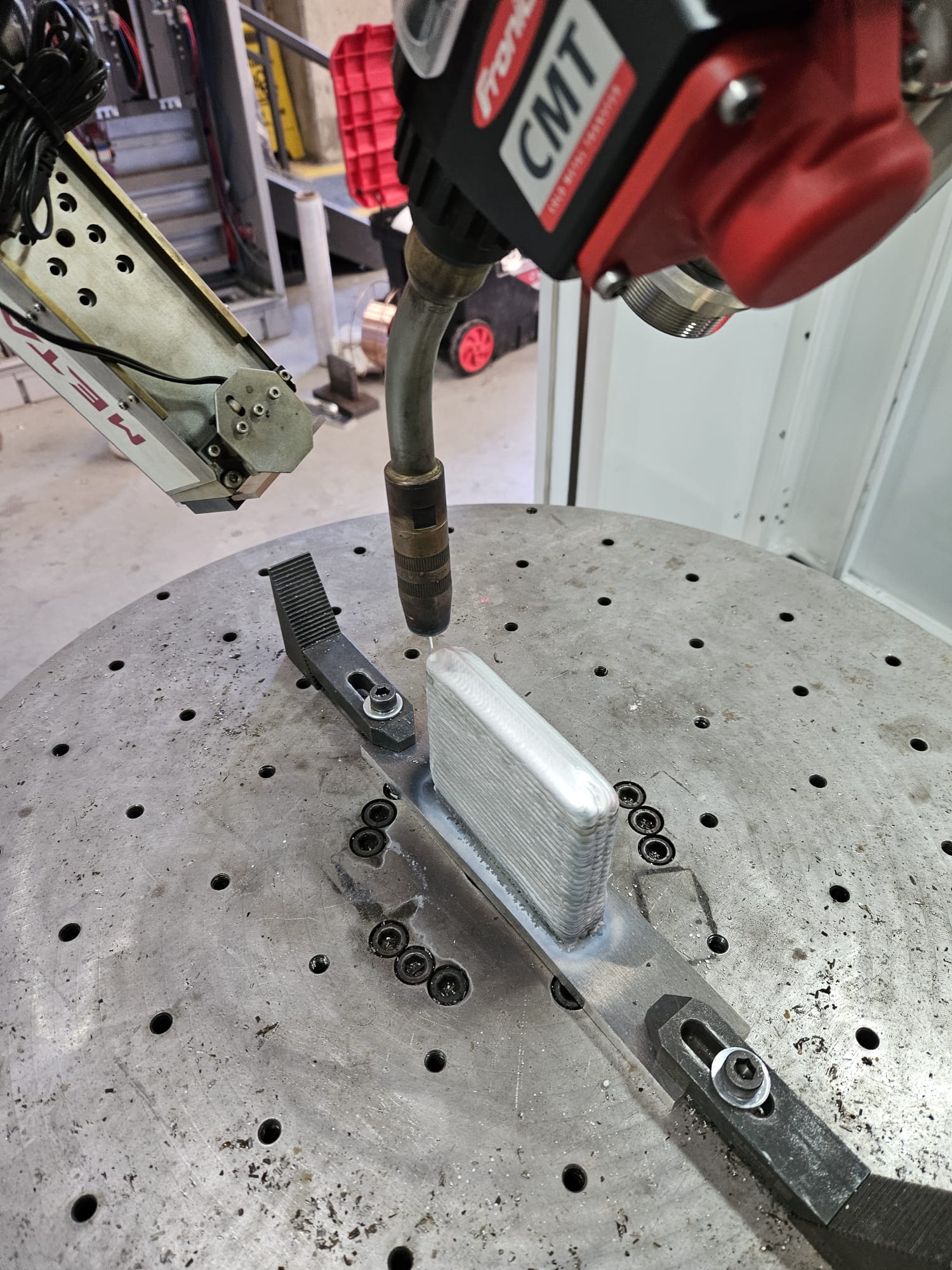 Robotic WAAM system depositing metallic wire layer by layer to manufacture a large industrial metal component