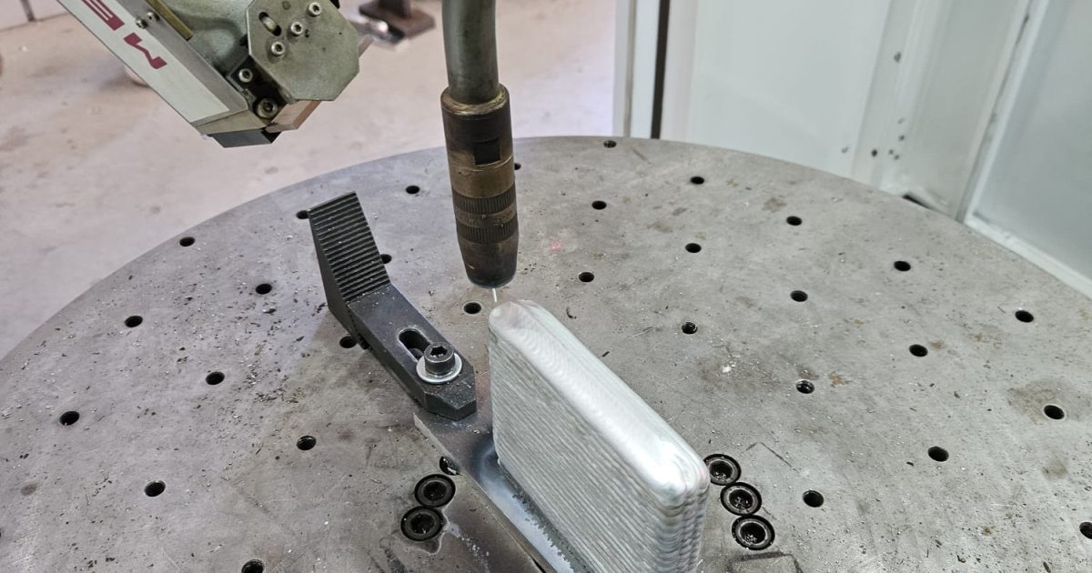 Robotic WAAM system depositing metallic wire layer by layer to manufacture a large industrial metal component